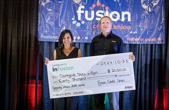 Woman From Countryside Studio And Gym Receivng Cheque From Winning Community Infusion